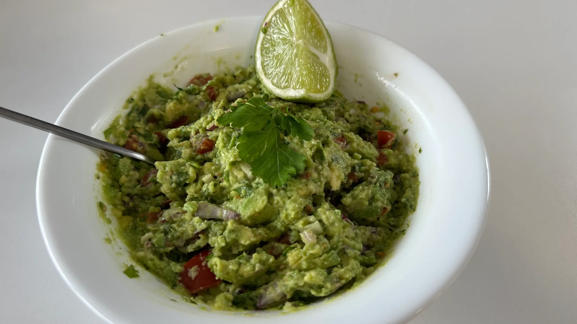 Guacamole proaspat cu un strop de lime si patrunjel deasupra