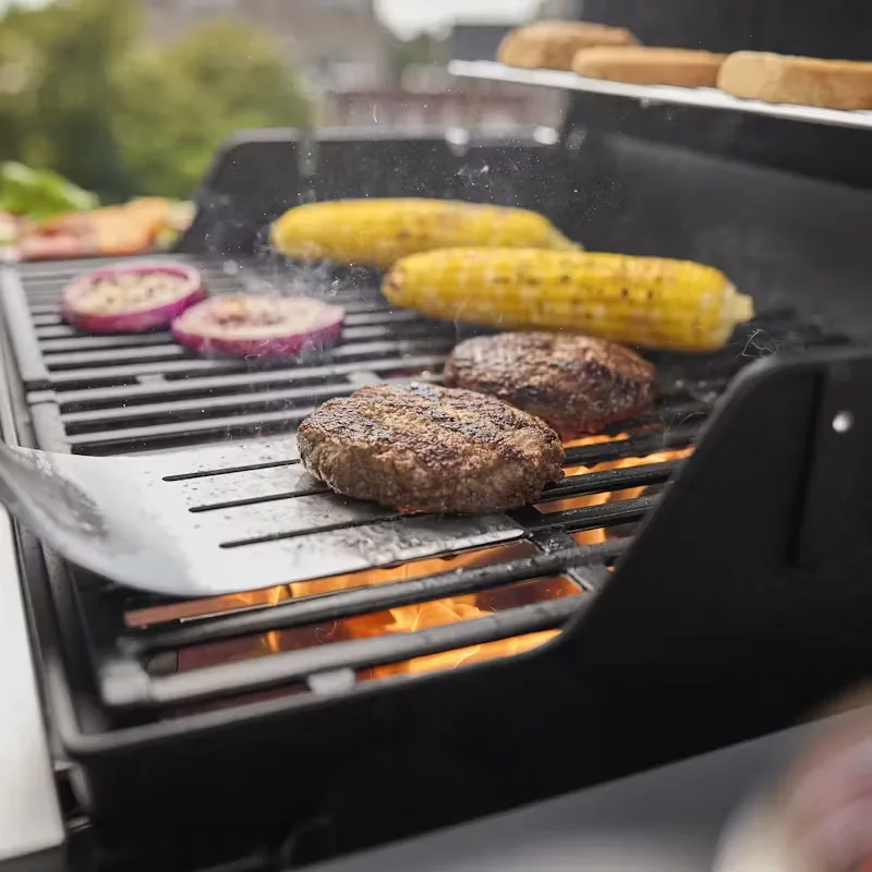Preparate delicioase la grătar pe gaz: burgeri, porumb dulce și ceapă caramelizată